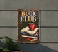a book club sign hanging on the side of a building