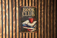 a book club sign hanging on a wooden wall