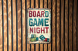 a sign on a wooden wall that says board game night