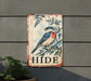 a bird is sitting on a sign that says hide