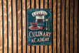 a sign on a wooden wall that says culinary academy