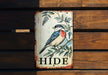 a bird painted on a sign on a wooden wall