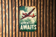 a sign on a wooden wall that says adventure awaits