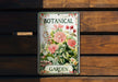 a botanical garden sign hanging on a wooden wall