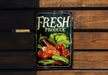 a fresh produce sign hanging on a wooden wall