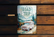 a road trip sign on a wooden bench