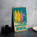 a surfboard rental sign next to a pair of binoculars