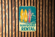 a surfboard rental sign on a wooden wall