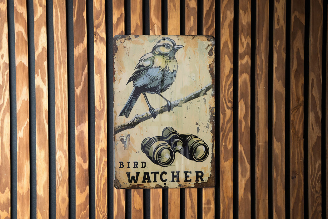 a bird sitting on a branch next to a pair of binoculars