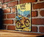a bicycle trail sign on a brick wall