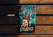 a sign that says art studio hanging on a wooden wall