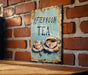 a sign on a brick wall that says afternoon tea