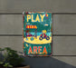 a play area sign hanging on a wall