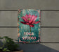 a sign that says yoga studio with a pink flower on it