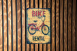 a sign on a wooden wall that says bike rental