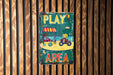 a sign on a wooden wall that says play area