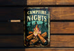 a campfire nights sign hanging on a wooden wall