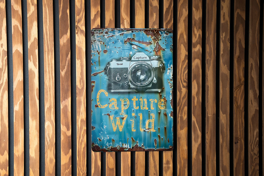 a sign on a wooden wall that says capture wild