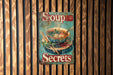a soup sign hanging on a wooden wall