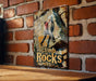 a picture of a climb rocks sign on a brick wall
