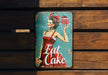 a metal sign with a woman holding a cake