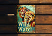 a metal sign that says wild watch with two lions