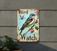 a bird watch sign hanging on the side of a building