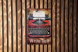 an old fashioned red typewriter on a wooden wall