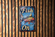 a fish on sign mounted to a wooden wall