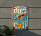 a bird is sitting on a sign that says bird call