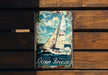 a metal sign with a sailboat on it