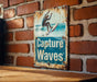 a sign on a brick wall that says capture waves