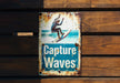 a sign on a wooden wall that says capture waves