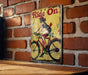 a picture of a woman riding a bike on a brick wall