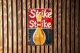 a sign on a wooden wall that says strike strike