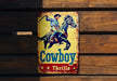 a cowboy tin sign mounted to a wooden wall