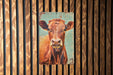 a painting of a cow on a wooden wall