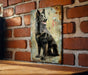 a picture of a dog is hanging on a brick wall