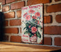 a flower nursery sign on a brick wall
