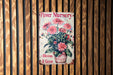 a flower nursery sign hanging on a wooden wall
