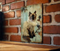 a picture of a cat hanging on a brick wall