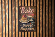 a sign on a wall that says bake sweet support