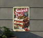 a sandwich deli sign on the side of a building