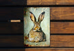 a metal sign with a picture of a rabbit on it