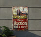 a farm auction sign on the side of a building
