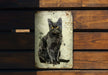 a black cat sitting on top of a wooden bench