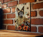 a picture of a siamese cat on a brick wall