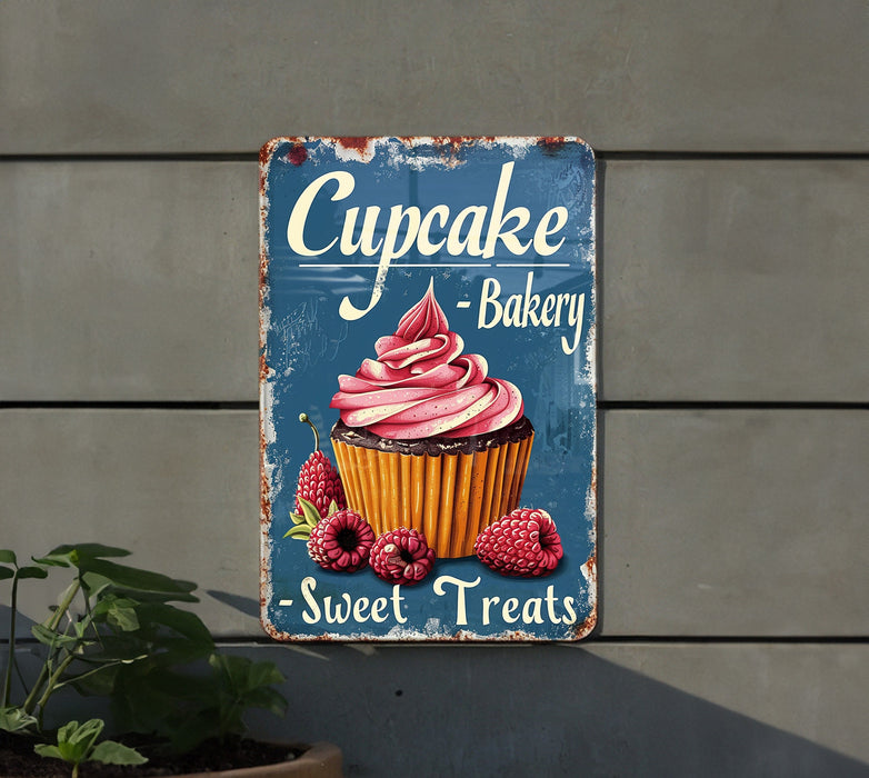 a cupcake bakery sign hanging on the side of a building