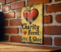a sign on a brick wall that says charity event love and give