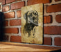 a picture of a dog hanging on a brick wall